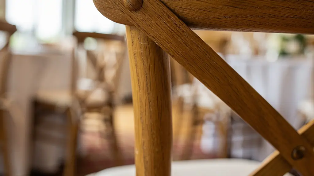 Gros plan sur l'assemblage et la finition d'une chaise Cross Back professionnelle en bois massif